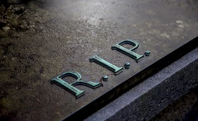Image of a tombstone with the letters ‘RIP’ on it