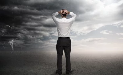 Businessman standing in a desert during a stormy weather