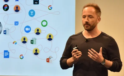 Drew Houston CEO Dropbox speaks at a Dropbox event with app icons behind