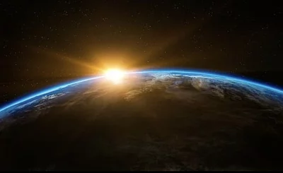 An image of the sun rising over planet earth