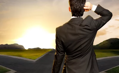 young businessman in front of a crossroad