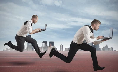 Two businessmen race with laptops in competition - © alphaspirit - Fotolia.com