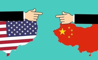 An image of outlines of USA and China, with a hand representing each country pointing in each other’s direction