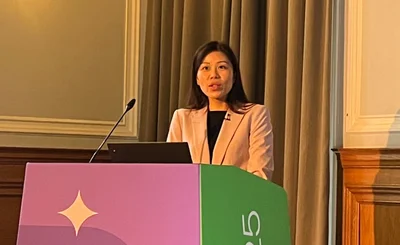 Ruby Tan, Safety National, speaks from behind a lectern at Perform 25 London