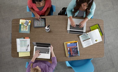 Team meeting around a table - via Steelcase