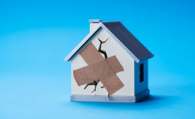 Animated house with bandage over crack in the wall, against a blue background.